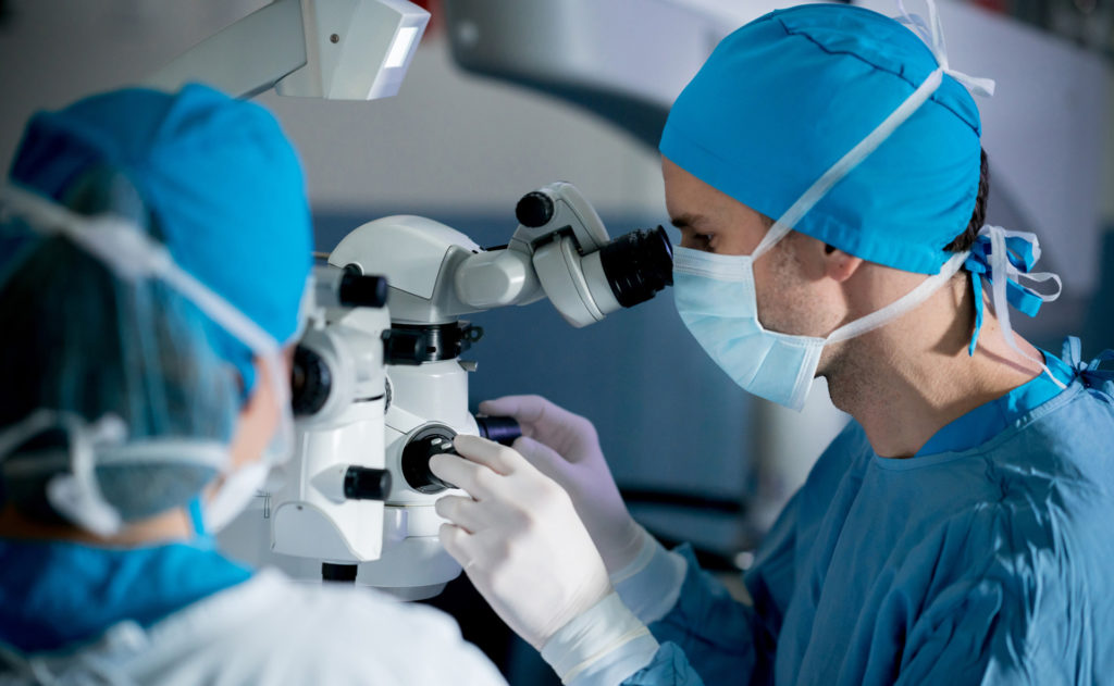 Surgeons performing an eye surgery under the microscope